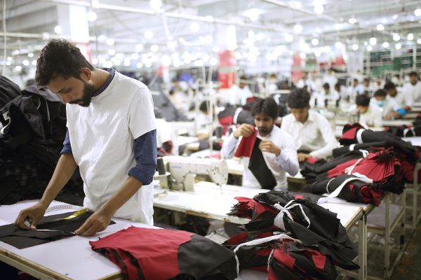 Des hommes au travail dans un atelier de couture